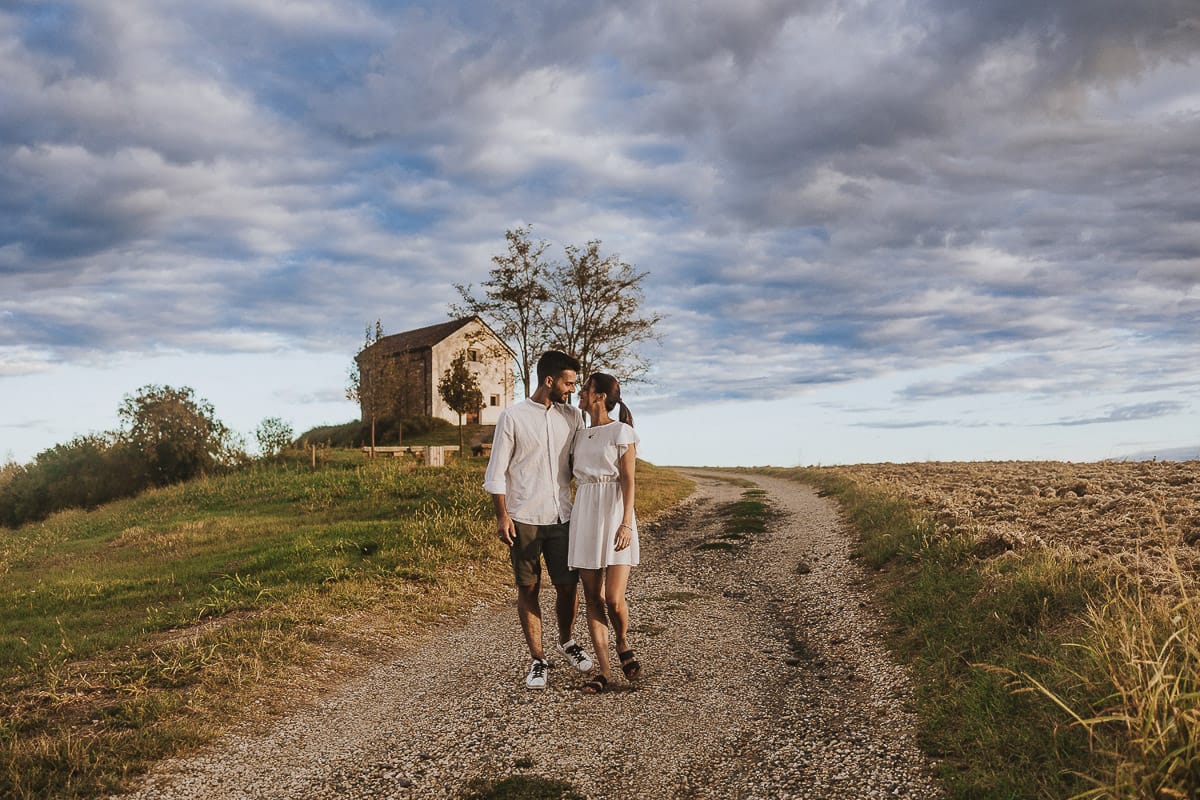 Prewedding spontaneo e poetico nel Monferrato a Mombello di Torino. Federica e Riccardo camminano abbracciati guardandosi