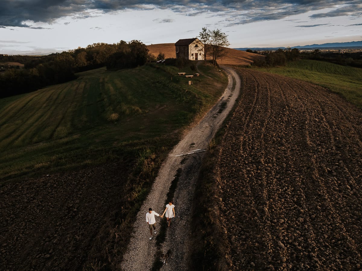 Prewedding spontaneo e poetico nel Monferrato a Mombello di Torino. Federica e Riccardo camminano dandosi la mano foto dal drone