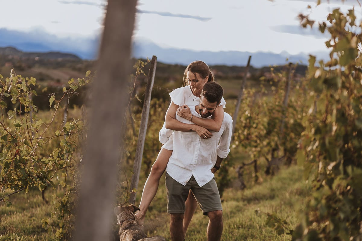 Prewedding spontaneo e poetico nel Monferrato a Mombello di Torino. Federica e Riccardo nel vigneto giocano. Federica salta sulla spalla di Riccardo.