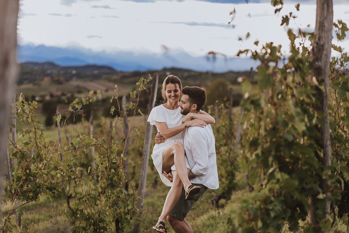 Prewedding spontaneo e poetico nel Monferrato a Mombello di Torino. Federica e Riccardo nel vigneto giocano. Riccardo prende in braccio Federica.