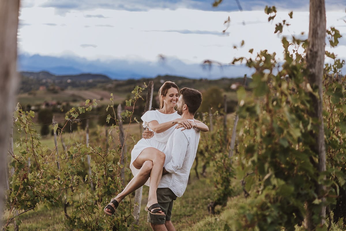 Prewedding spontaneo e poetico nel Monferrato a Mombello di Torino. Federica e Riccardo nel vigneto giocano. Riccardo prende in braccio Federica.