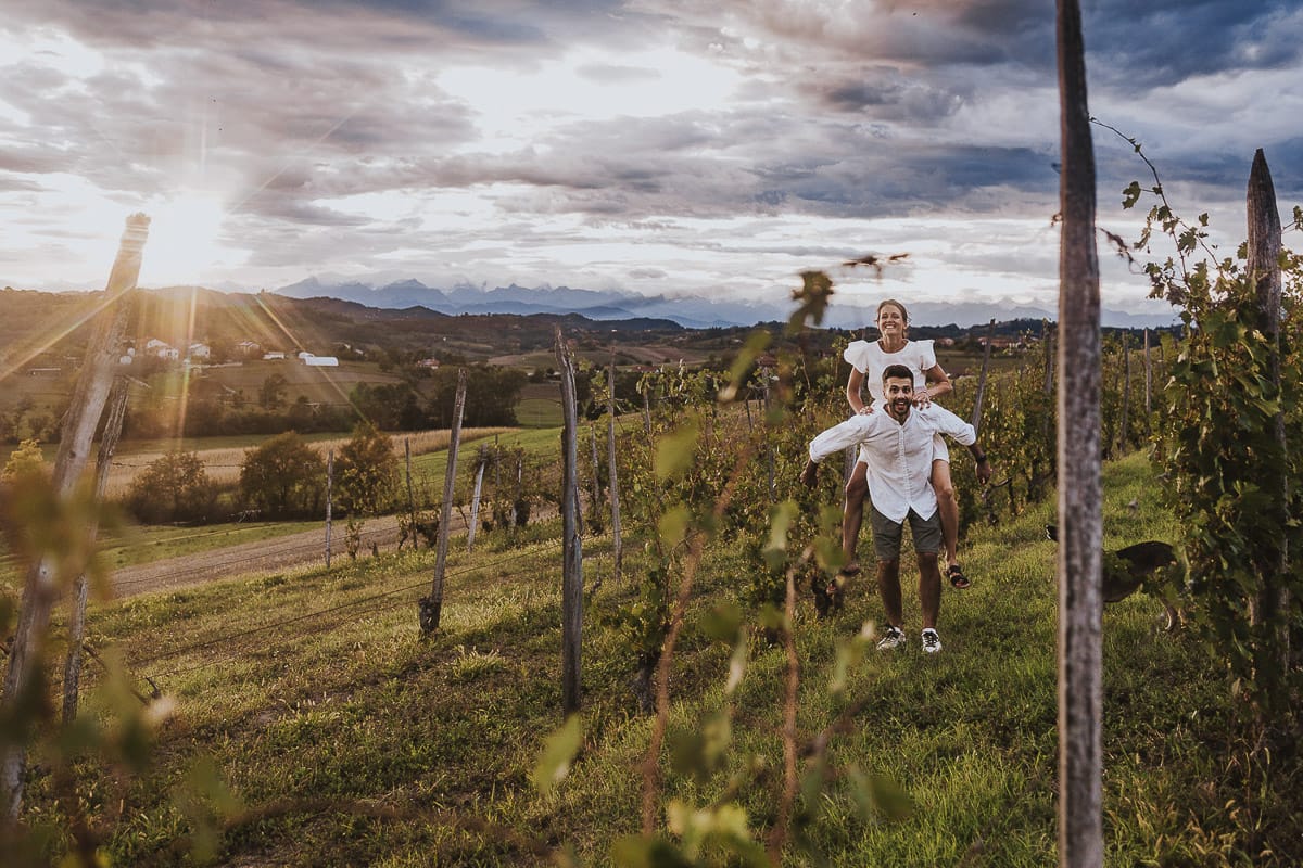 Prewedding spontaneo e poetico nel Monferrato a Mombello di Torino. Federica e Riccardo nel vigneto giocano. Federica salta sulla spalla di Riccardo.