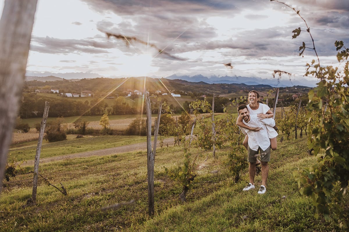 Prewedding spontaneo e poetico nel Monferrato a Mombello di Torino. Federica e Riccardo nel vigneto giocano. Federica salta sulla spalla di Riccardo.