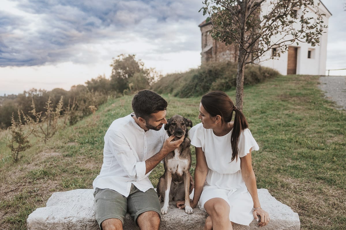 Prewedding spontaneo e poetico nel Monferrato a Mombello di Torino. Riccardo e Federica seduti su di una panchina di pietra con la cagnolina