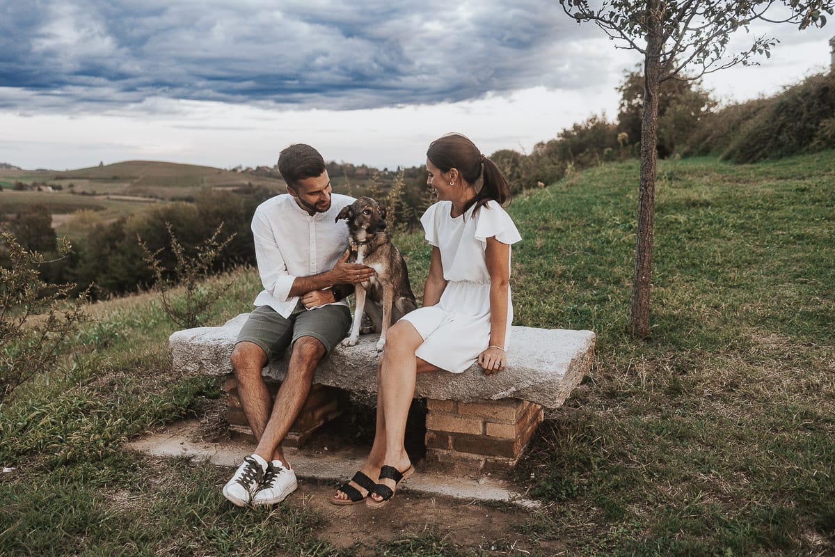 Prewedding spontaneo e poetico nel Monferrato a Mombello di Torino. Riccardo e Federica seduti su di una panchina di pietra con la cagnolina