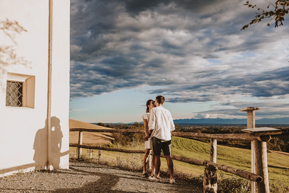 Prewedding spontaneo e poetico nel Monferrato a Mombello di Torino. Federica e Riccardo si baciano davanti alla chiesa di san Lorenzo