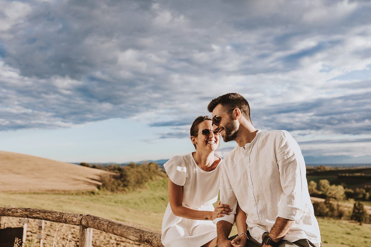 Prewedding spontaneo e poetico nel Monferrato. Federica e Riccardo seduti su di una staccionata di legno.