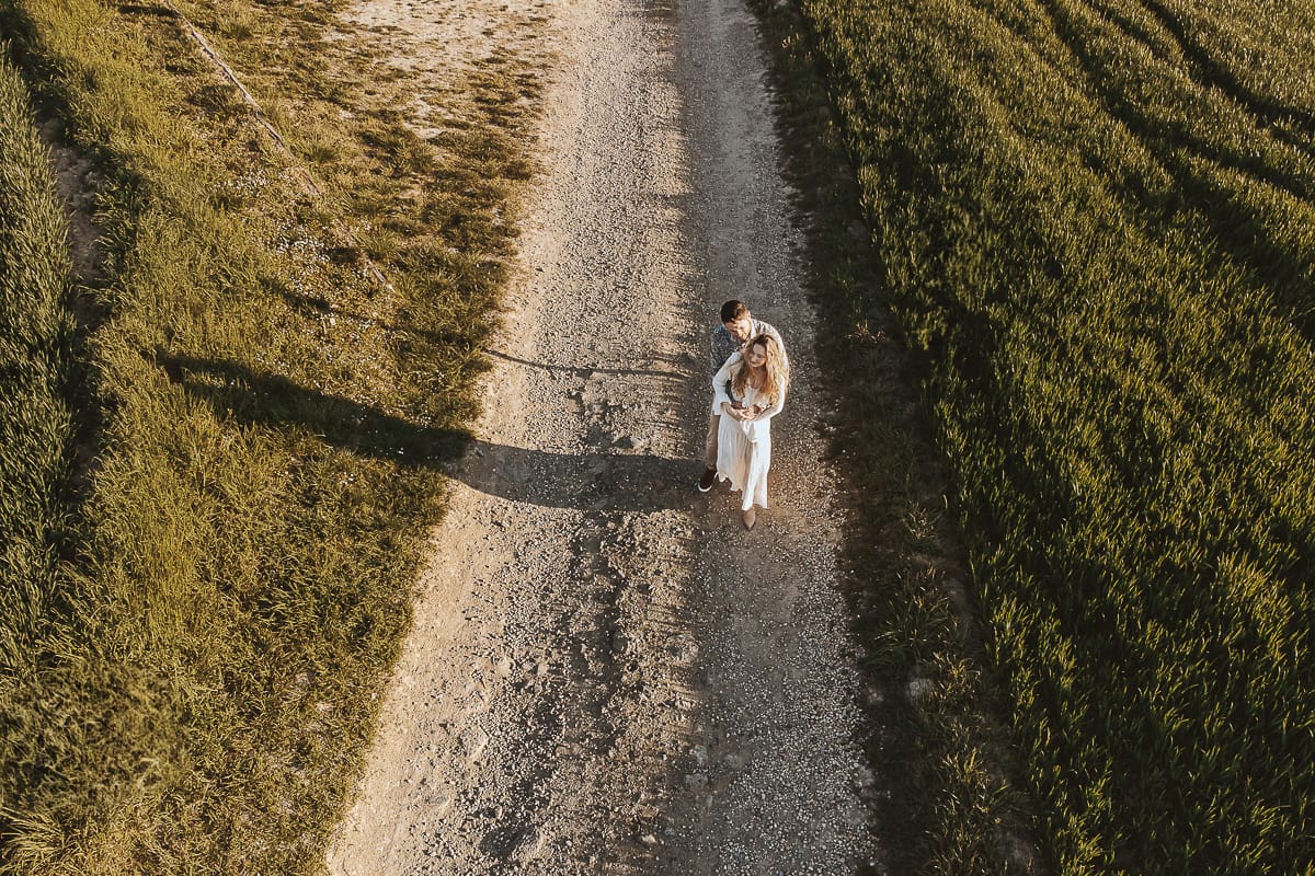 Scrivi il tag alt relativo alla foto di Anita e Davide, futuri sposi, che passeggianno sul sentiero nella zona della chiesetta romanica di San Lorenzo a Mombello di Torino in una splendida giornata di inizio primavera. Il cielo e azzurro e c'è una splendida vista sulle colline del Monferrato torinese