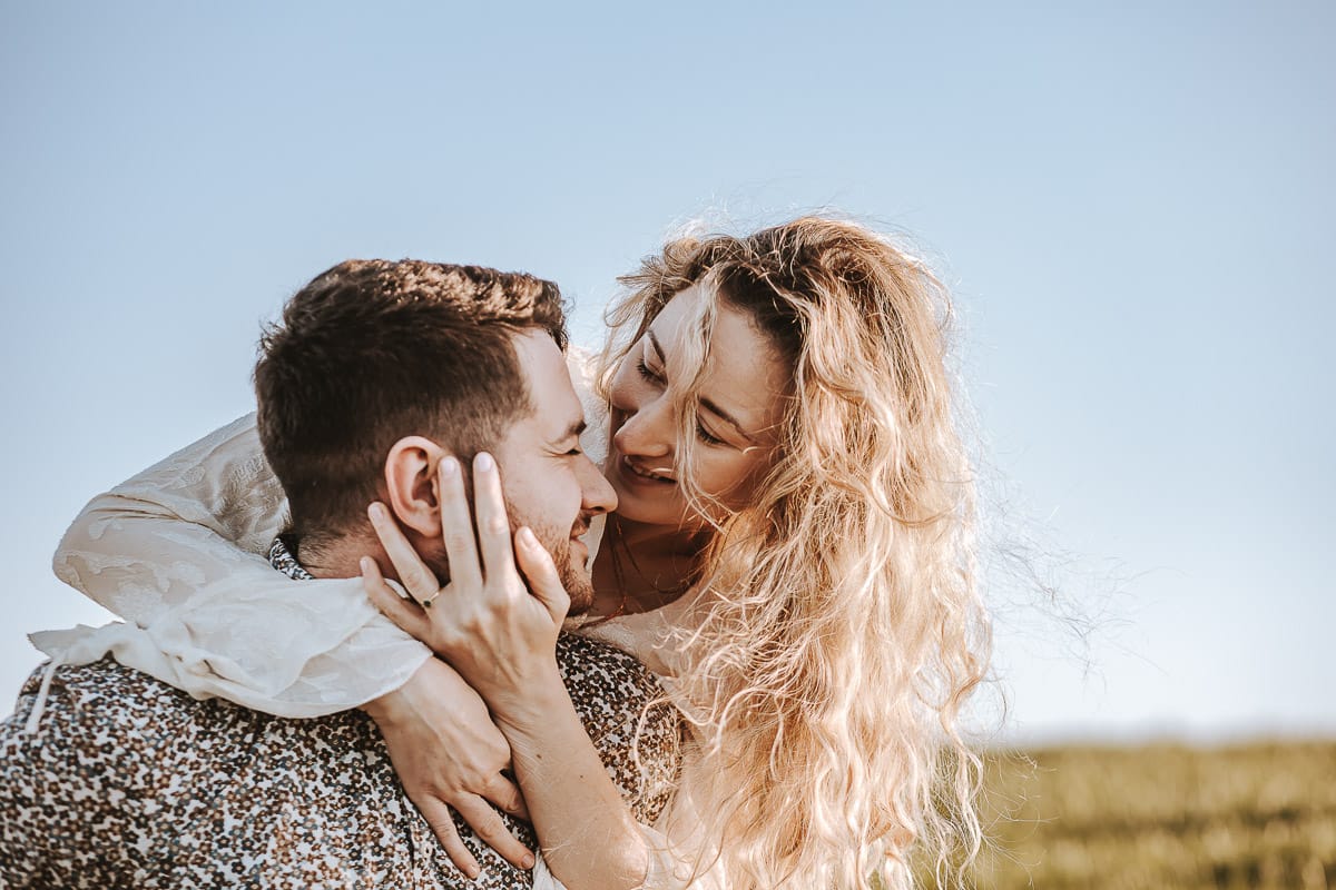 Mombello di Torino, Monferrato: Anita e Davide, raggianti di felicità, si scambiano un bacio davanti a una chiesetta romanica in un pittoresco pomeriggio primaverile. La foto cattura l'amore e l'emozione che precedono il loro matrimonio.
