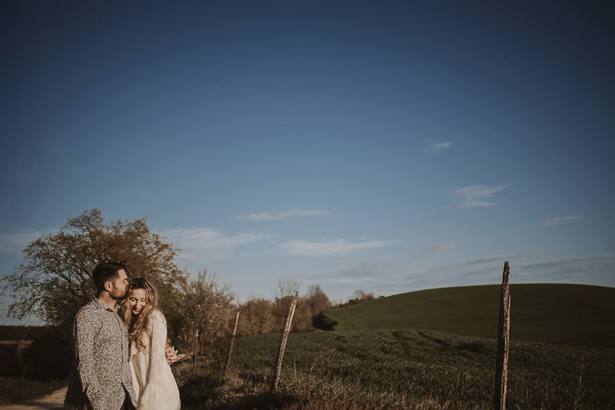 Tag alt per la foto di Anita e Davide a Mombello di Torino: Opzione 1: Anita e Davide, mano nella mano, passeggiano felici sul sentiero che conduce alla chiesetta romanica di San Lorenzo a Mombello di Torino, immersi nei colori di una splendida giornata primaverile. Sullo sfondo, il cielo azzurro e le colline del Monferrato torinese offrono una vista mozzafiato.