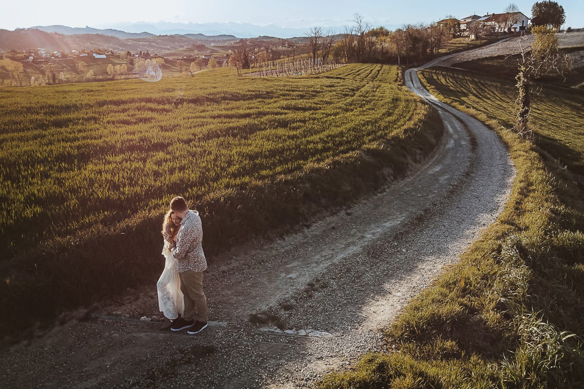 Anita e Davide, immersi nella bellezza del Monferrato, passeggiano mano nella mano verso il loro futuro di sposi. La foto, ripresa dall'alto dal drone, cattura la magia di questo momento speciale.