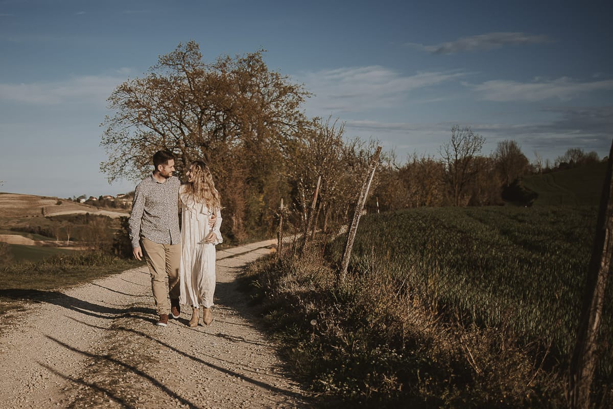 Tag alt per la foto di Anita e Davide a Mombello di Torino: Opzione 1: Anita e Davide, mano nella mano, passeggiano felici sul sentiero che conduce alla chiesetta romanica di San Lorenzo a Mombello di Torino, immersi nei colori di una splendida giornata primaverile. Sullo sfondo, il cielo azzurro e le colline del Monferrato torinese offrono una vista mozzafiato.