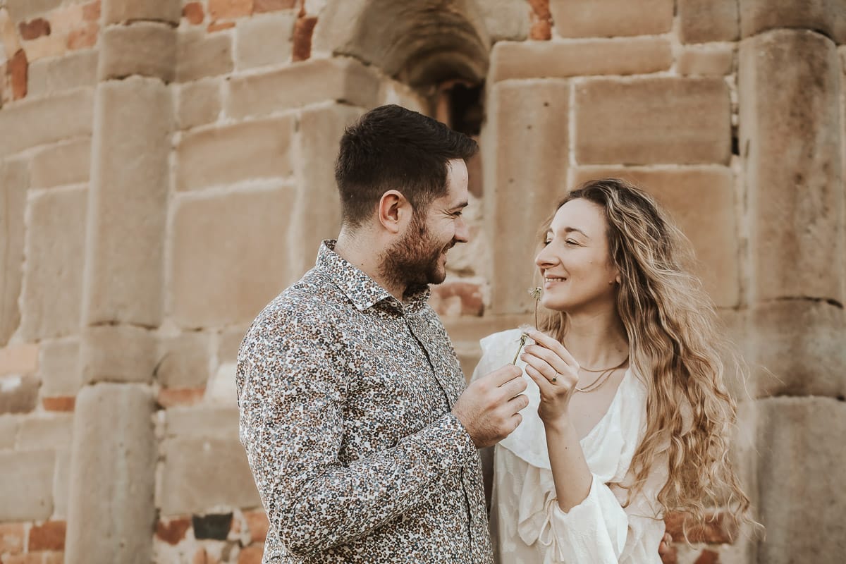 Un ritratto romantico di Anita e Davide, futuri sposi, in una soleggiata giornata primaverile. La coppia si trova di fronte a una chiesetta romanica a Mombello di Torino, nel cuore del Monferrato