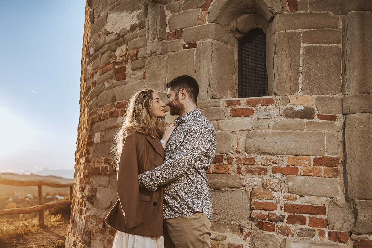 Un ritratto romantico di Anita e Davide, futuri sposi, in una soleggiata giornata primaverile. La coppia si trova di fronte a una chiesetta romanica a Mombello di Torino, nel cuore del Monferrato