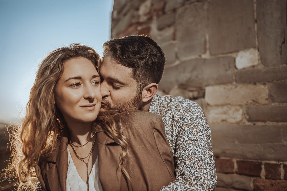 Un ritratto romantico di Anita e Davide, futuri sposi, in una soleggiata giornata primaverile. La coppia si trova di fronte a una chiesetta romanica a Mombello di Torino, nel cuore del Monferrato