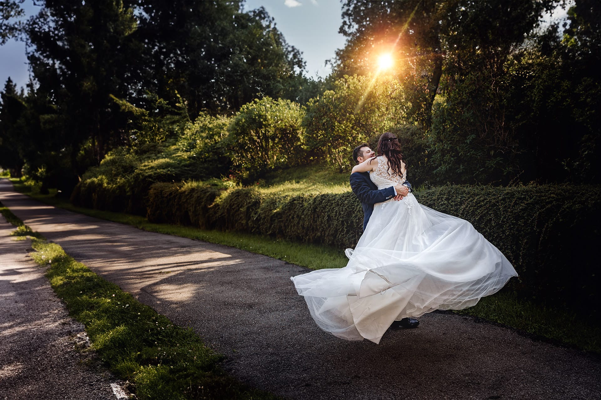 Matrimonio nele Monferrato. Ritratto degli sposi. Alessandro prende in braccio e fa fare un giro a Martina. Sole dietro gli sposi