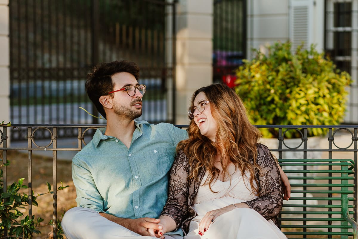 Fotografo matrimonio Rivalba. Villa Ala. Prewedding di Giorgia e Marco. Golden Hour. La coppia è seduti su di una panchina di ferro battuto, davanti alla villa sotto un gazebo in ferro battuto.