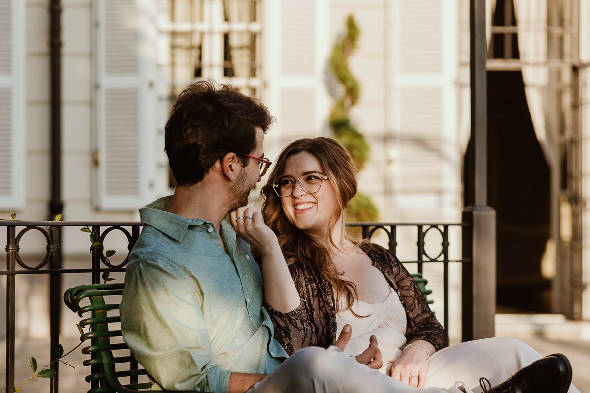 Fotografo matrimonio Rivalba. Villa Ala. Prewedding di Giorgia e Marco. Golden Hour. La coppia è seduti su di una panchina di ferro battuto, davanti alla villa sotto un gazebo in ferro battuto.