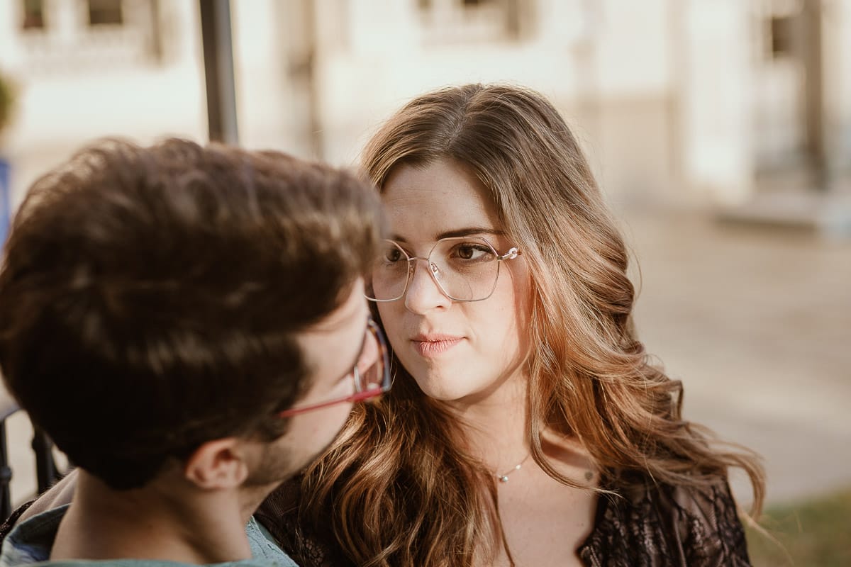 Fotografo matrimonio Rivalba. Villa Ala. Prewedding di Giorgia e Marco. Golden Hour. La coppia è seduti su di una panchina di ferro battuto, davanti alla villa sotto un gazebo in ferro battuto. Ritratto ravvicinato. Giorgia guarda Marco teneramente