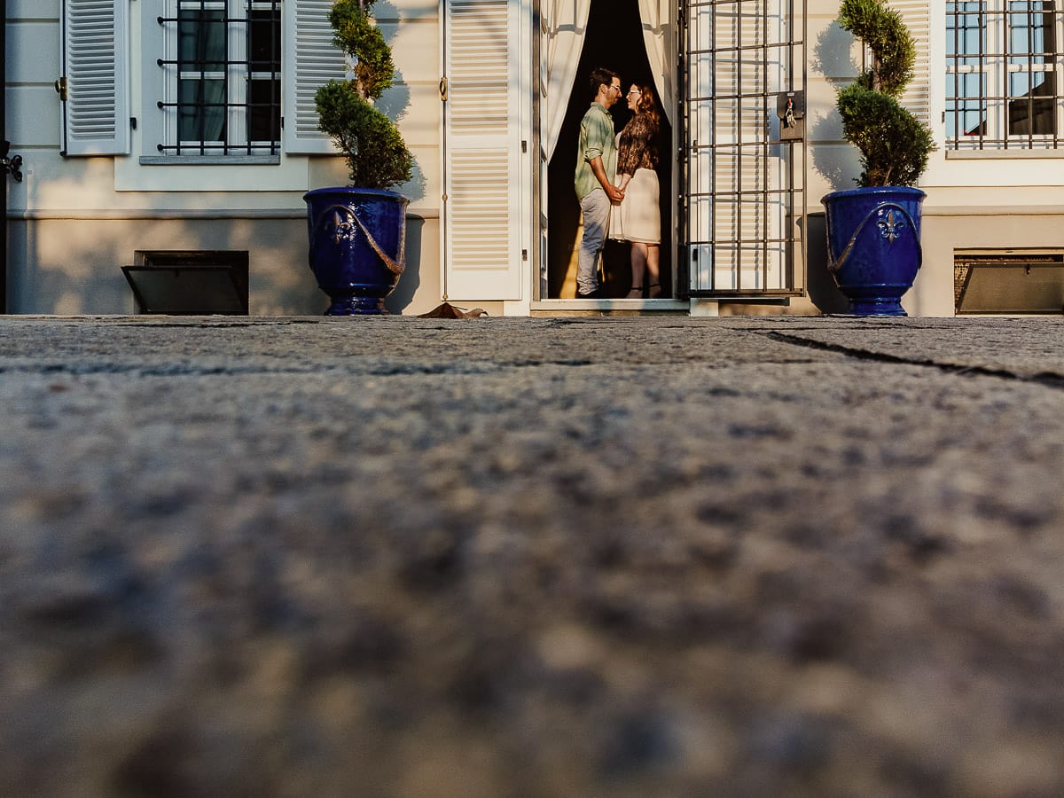 Fotografo matrimonio Rivalba. Villa Ala. Prewedding di Giorgia e Marco. Golden Hour. La coppia entra nella villa. Coppia ripresa dal drone posato per terra, in mezzo ad una delle porte.