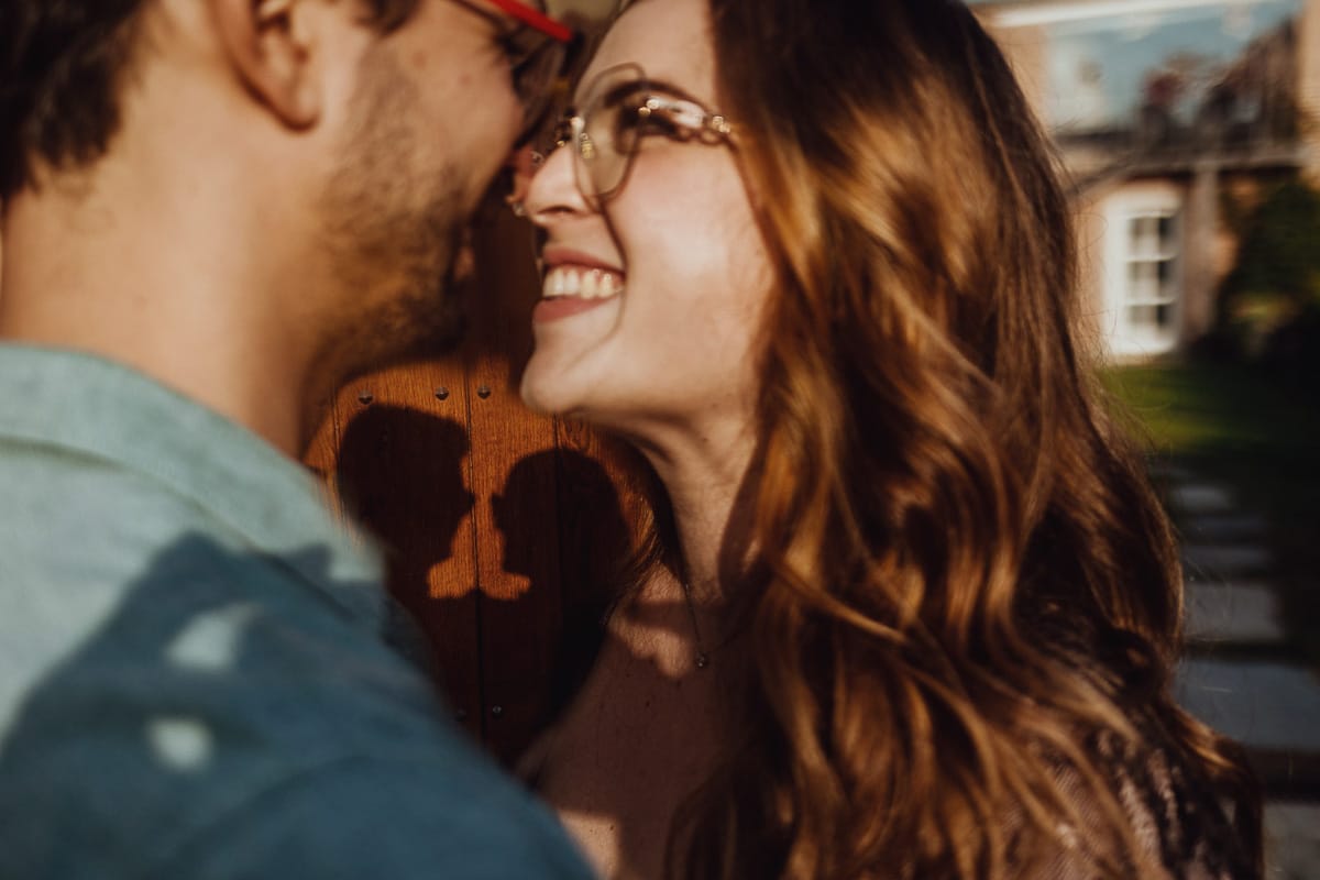 Fotografo matrimonio Rivalba. Villa Ala. Prewedding di Giorgia e Marco. Ritratto da vicino della coppia che si guarda. Tra di loro la loro ombra proiettata sulla porta di legno dietro di loro.