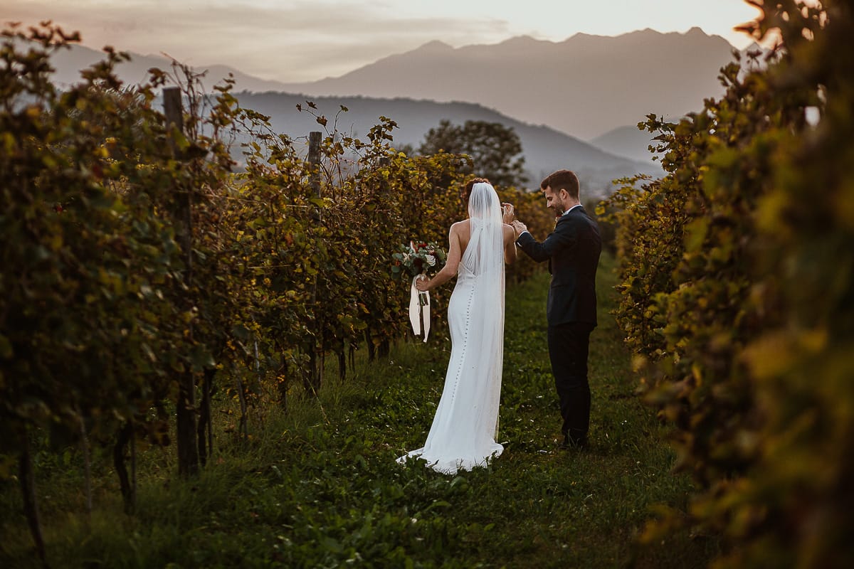 Fotografo matrimonio Torino. Matrimonio eco-consapevole a Cascina Ranverso. Ritratto degli sposi al tramonto. Sposi passeggiano nel vigneto.