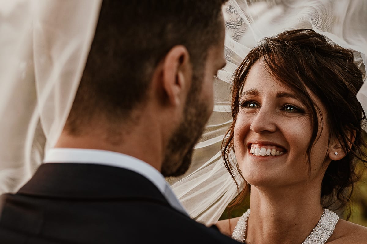 Fotografo matrimonio Torino. Matrimonio eco-consapevole a Cascina Ranverso. Ritratto degli sposi al tramonto. Sposi nel vigneto sotto il velo