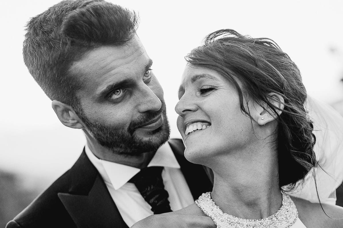 Fotografo matrimonio Torino. Matrimonio eco-consapevole a Cascina Ranverso. Ritratto degli sposi al tramonto. Sposi nel vigneto lo sposo abbraccia la sposa