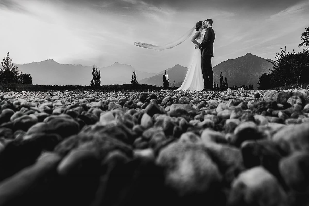 Fotografo matrimonio Torino. Matrimonio eco-consapevole a Cascina Ranverso. Ritratto degli sposi al tramonto. Foto dal drone posto sul terreno. Bianco e nero.
