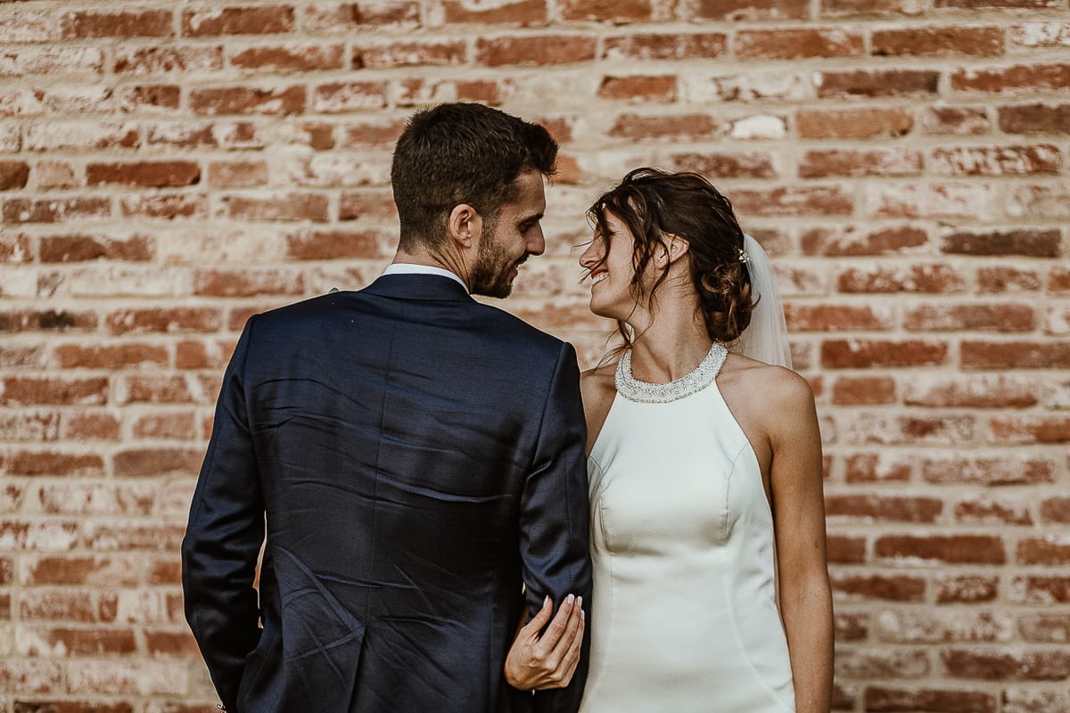 Fotografo matrimonio Torino. Matrimonio eco-consapevole a Cascina Ranverso. Ritratto degli sposi al tramonto. Gli sposi si guardano.