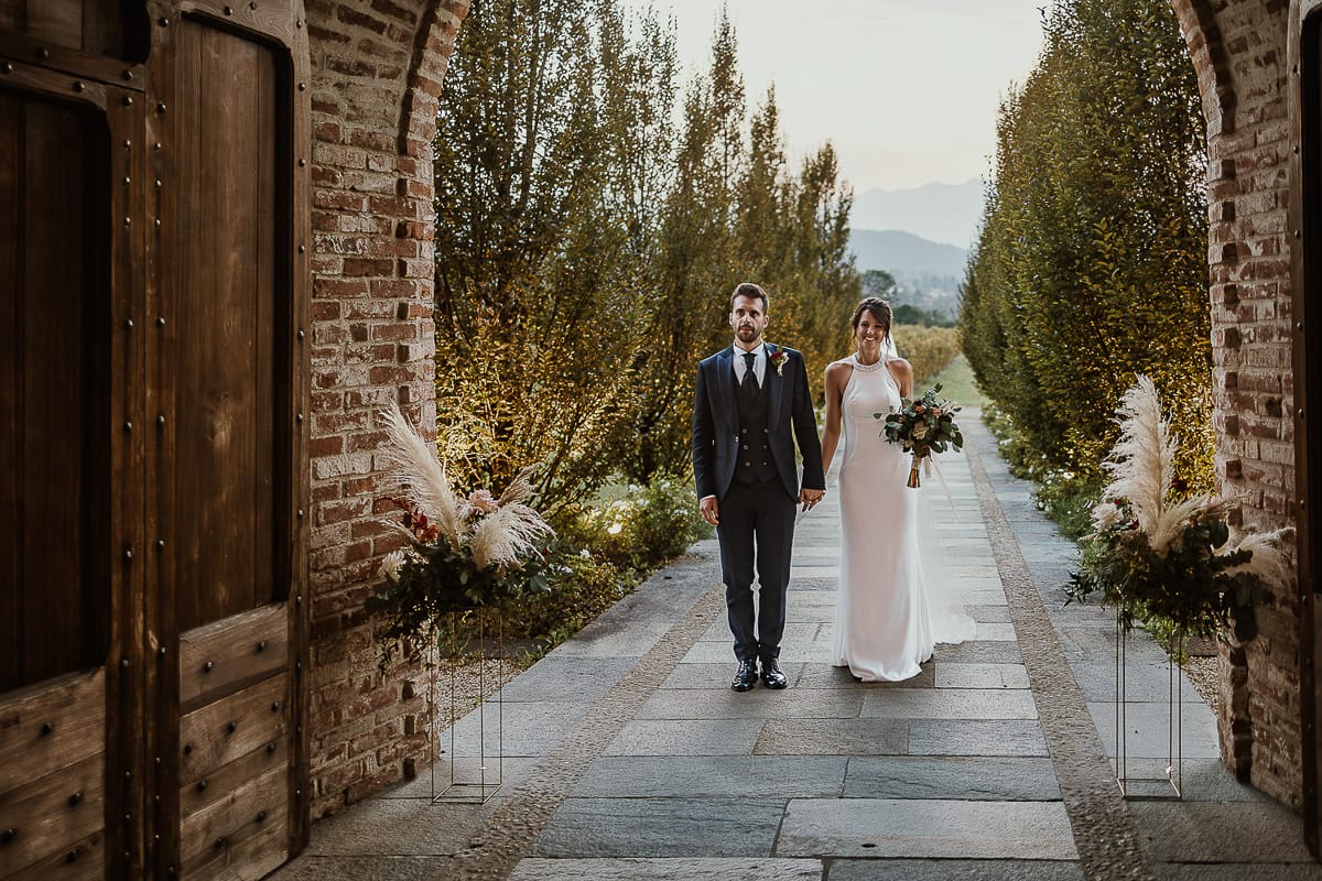 Fotografo matrimonio Torino. Matrimonio eco-consapevole a Cascina Ranverso. Ritratto degli sposi al tramonto. Gli sposi stanno per entrare nella location
