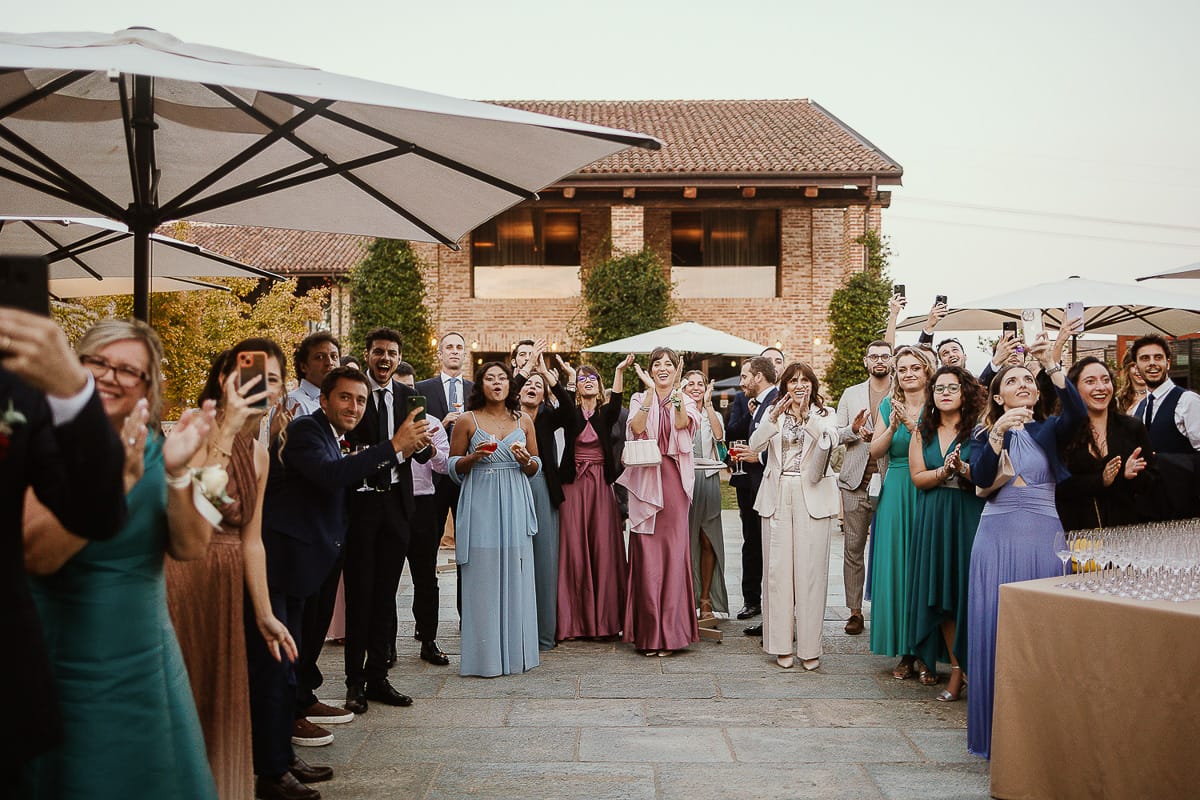 Fotografo matrimonio Torino. Matrimonio eco-consapevole a Cascina Ranverso. Ritratto degli sposi al tramonto. Gli invitati accolgono gli sposi con un applauso