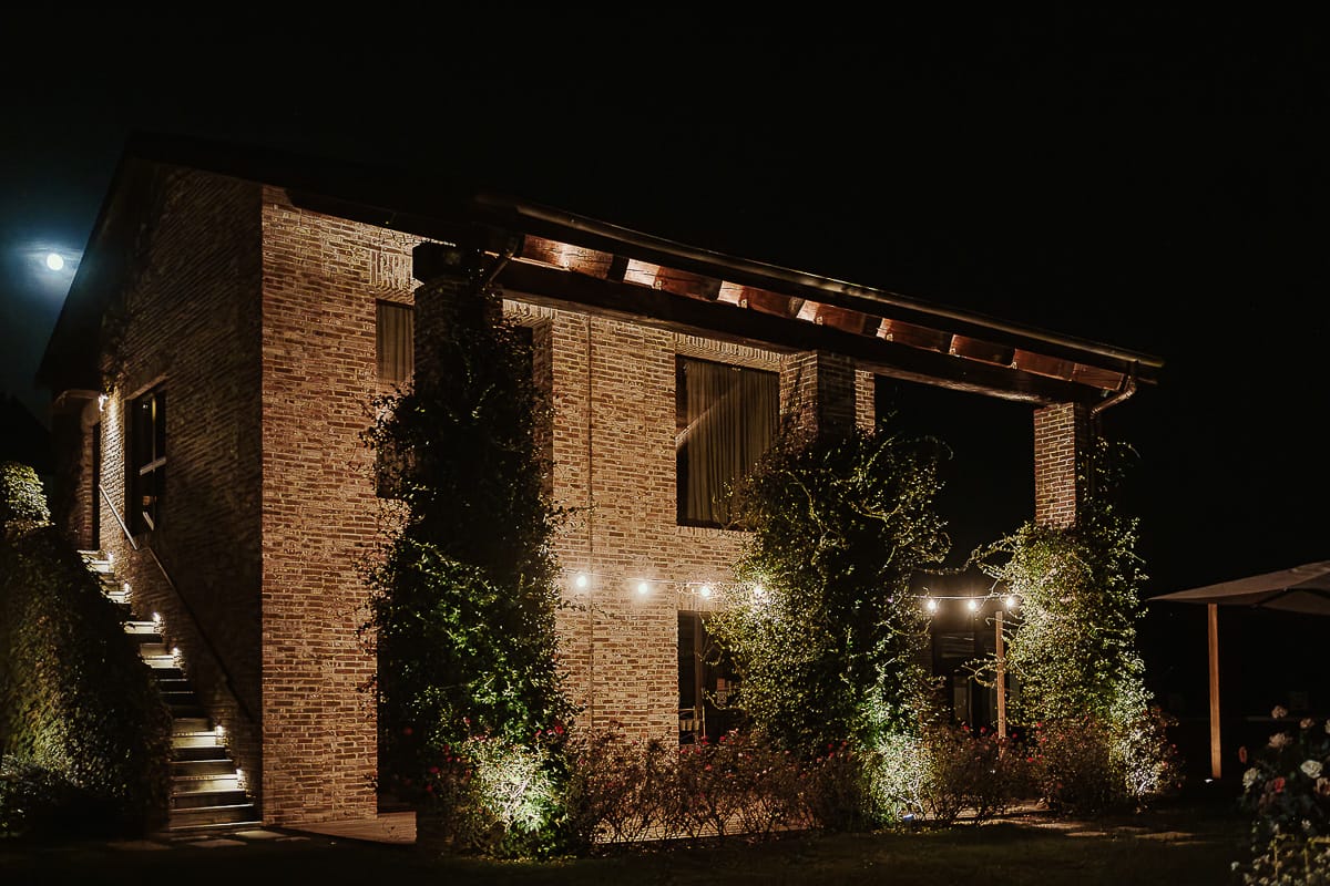 Fotografo matrimonio Torino. Matrimonio eco-consapevole a Cascina Ranverso. Cena. Esterno di un ala della location con le luci.