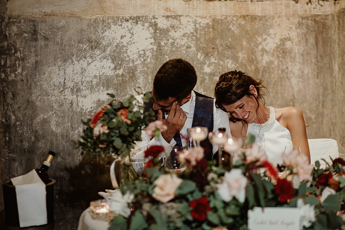 Fotografo matrimonio Torino. Matrimonio eco-consapevole a Cascina Ranverso. Cena. Discorso del papà dello sposo. Sposi imbarazzati ascoltano