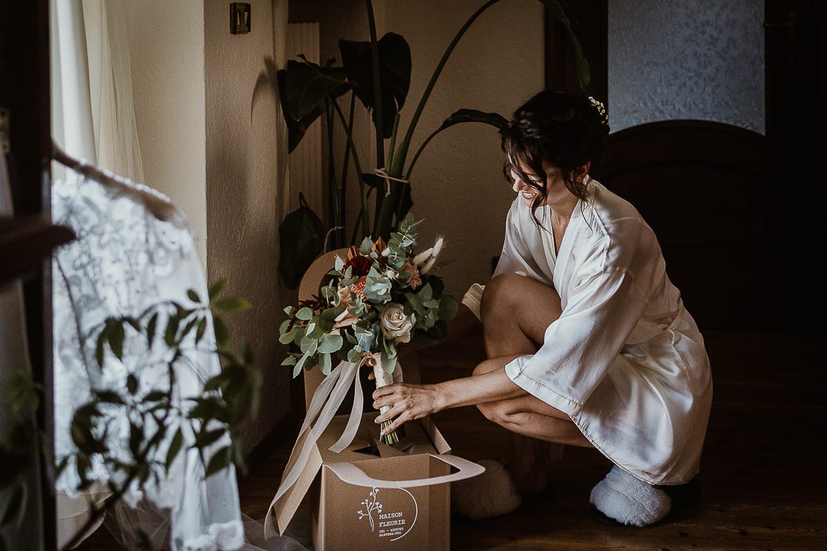 Fotografo matrimonio Torino. Matrimonio eco-consapevole a Cascina Ranverso. Preparazione della sposa a Chieri. Sposa estrae il bouquet dalla scatola