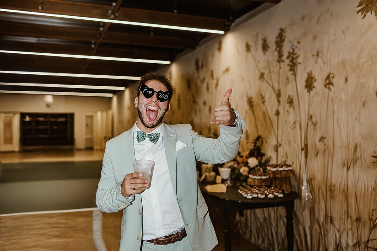 Fotografo matrimonio Torino.eco-consapevole a Cascina Ranverso. Festa. Invitato con occhiali a cuore con le iniziali degli sposi