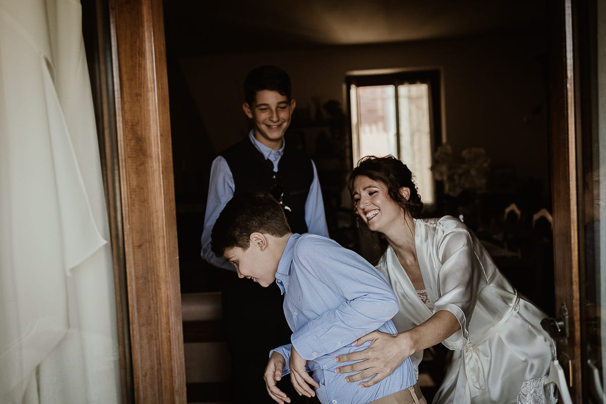Fotografo matrimonio Torino. Matrimonio eco-consapevole a Cascina Ranverso. Preparazione della sposa a Chieri. Sposa gioca con i cuginetti