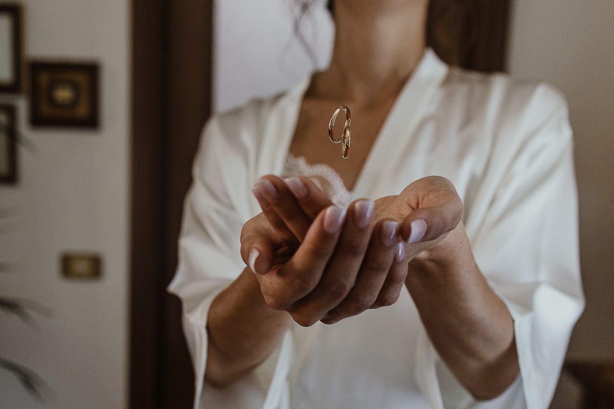 Fotografo matrimonio Torino. Matrimonio eco-consapevole a Cascina Ranverso. Preparazione della sposa a Chieri. Sposa con gli anelli