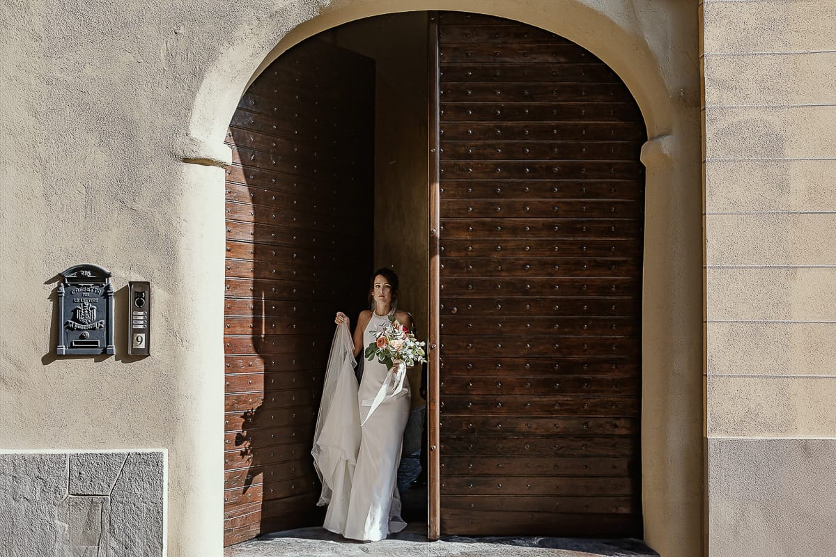 Fotografo matrimonio Torino. Matrimonio eco-consapevole a Cascina Ranverso. Preparazione della sposa a Chieri. Sposa esce dal portone di casa