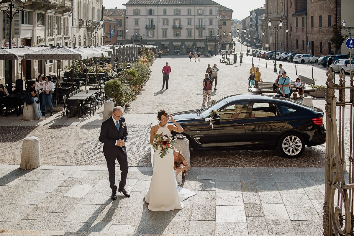 Fotografo matrimonio Torino. Matrimonio eco-consapevole a Cascina Ranverso. Cerimonia a Chieri nella chiesa dei Santi Bernardino e Rocco. Sposa e padre fuori dall'auto