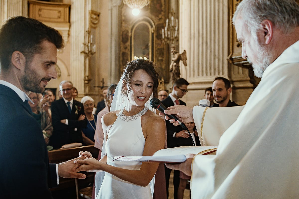 Fotografo matrimonio Torino. Matrimonio eco-consapevole a Cascina Ranverso. Cerimonia a Chieri nella chiesa dei Santi Bernardino e Rocco. Messa. Sposa mette l'anello al dito dello sposo