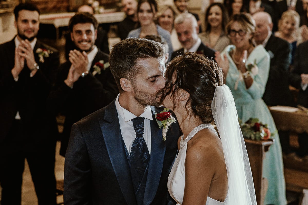 Fotografo matrimonio Torino. Matrimonio eco-consapevole a Cascina Ranverso. Cerimonia a Chieri nella chiesa dei Santi Bernardino e Rocco. Messa. Bacio