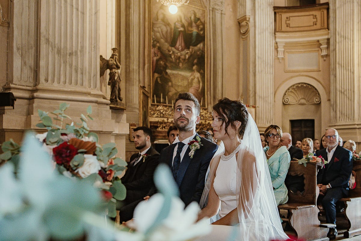 Fotografo matrimonio Torino. Matrimonio eco-consapevole a Cascina Ranverso. Cerimonia a Chieri nella chiesa dei Santi Bernardino e Rocco. Messa. Sposo guarda in alto