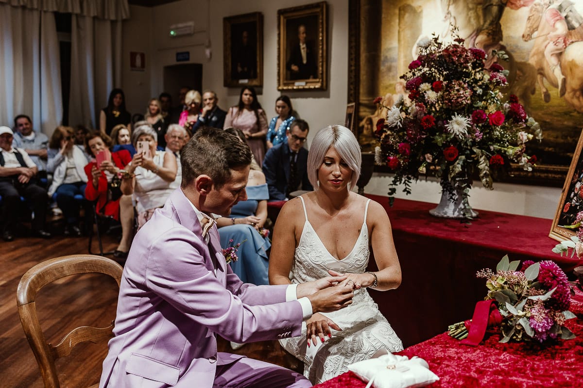 Matrimonio boho-chic da favola nel Monferrato. Fotografo matrimonio Monferrato. matrimonio a Molare (AL). cerimonia civile nel comune di Molare. Sposo mette l'anello alla sposa.