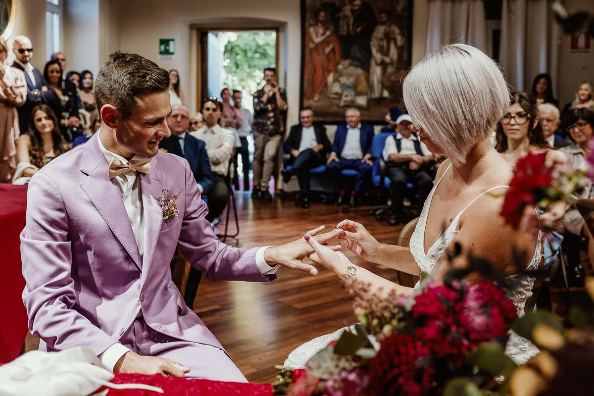 Matrimonio boho-chic da favola nel Monferrato. Fotografo matrimonio Monferrato. matrimonio a Molare (AL). cerimonia civile nel comune di Molare. Sposa mette l'anello allo sposo.