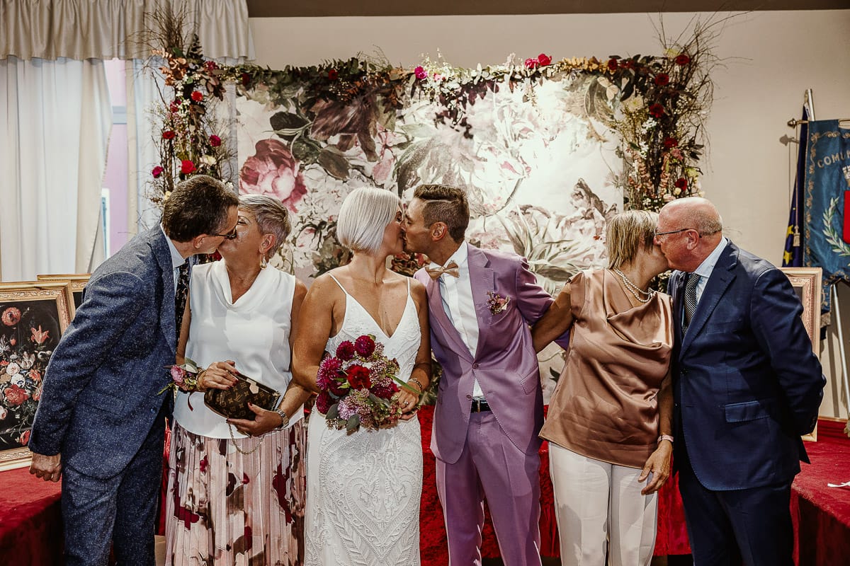 Matrimonio boho-chic da favola nel Monferrato. Fotografo matrimonio Monferrato. matrimonio a Molare (AL). cerimonia civile nel comune di Molare. Bacio degli sposi e dei genitori