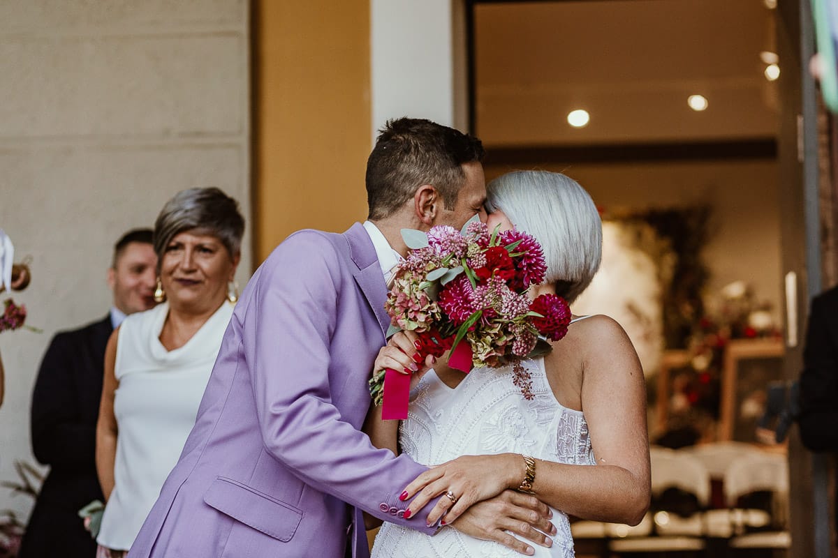 Matrimonio boho-chic da favola nel Monferrato. Fotografo matrimonio Monferrato. matrimonio a Molare (AL). cerimonia civile nel comune di Molare. Lancio del riso.Bacio dietro il bouquet