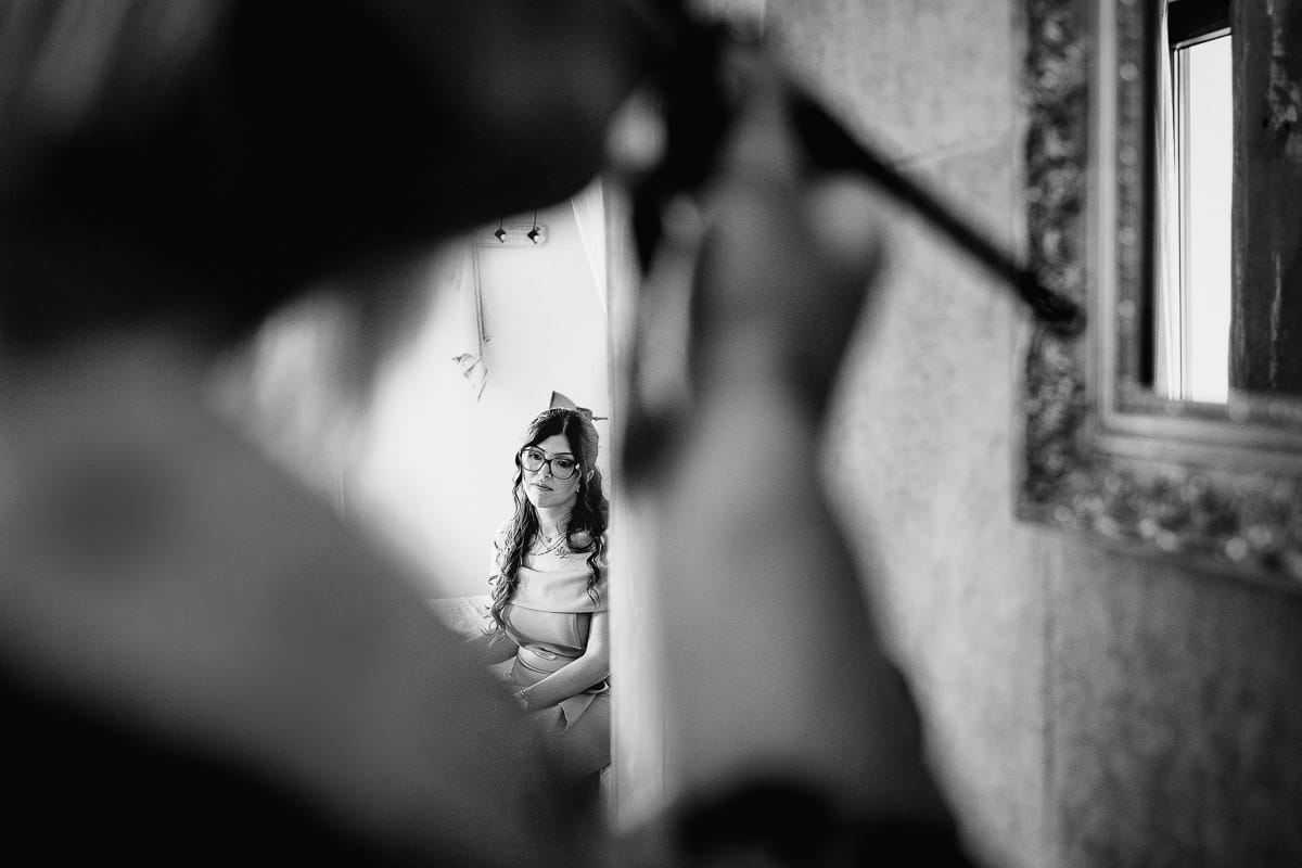 Matrimonio boho-chic da favola nel Monferrato. Matrimonio a Molare. Agriturismo "A Modo Mio". Preparazione della sposa.La sposa si trucca da sola in bagno. La testimone aspetta seduta sul letto.
