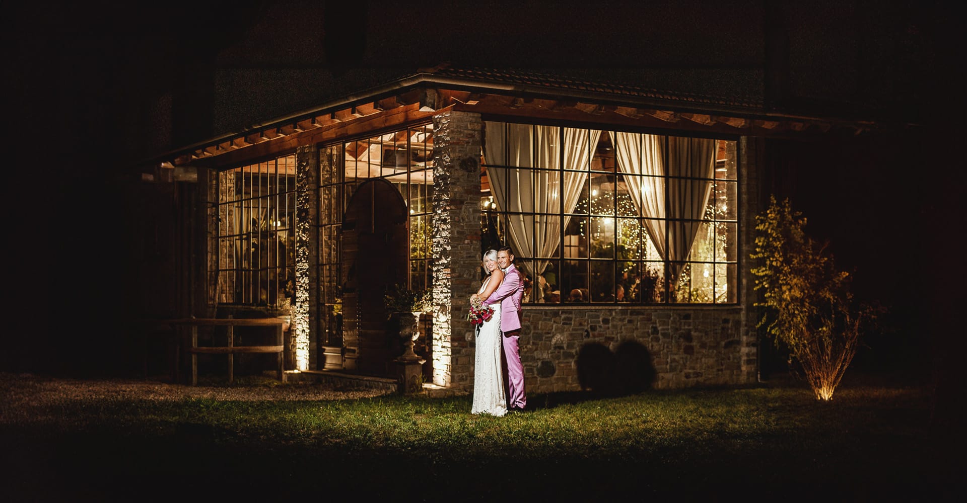 Matrimonio boho-chic da favola nel Monferrato all'agriturismo A Modo Mio di Molare (AL). Fiammetta e matteo durante la cena fuori dell'agriturismo illuminato con le luci di Natale. Flash esterno per illuminare gli sposi.