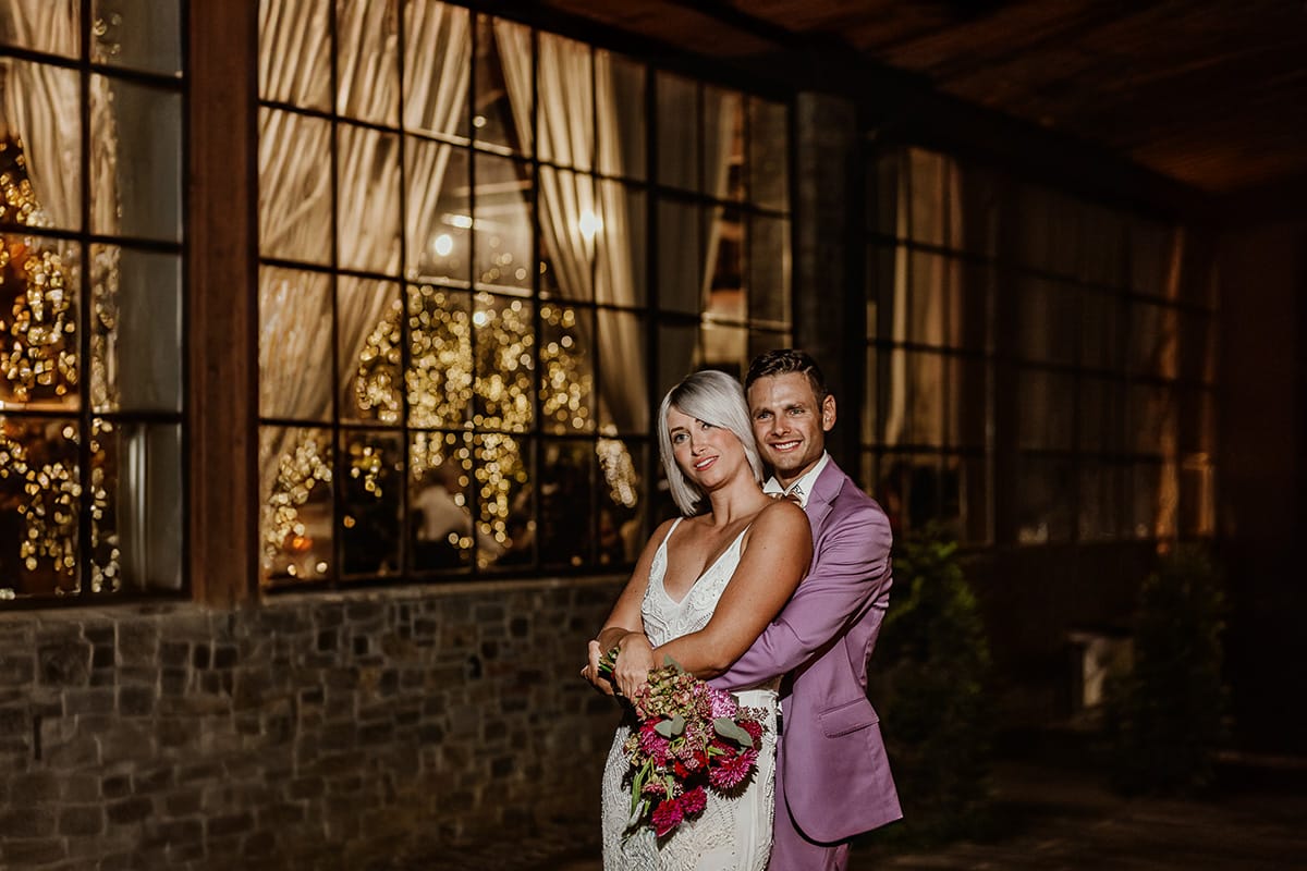 Matrimonio boho-chic da favola nel Monferrato. Fotografo matrimonio Monferrato. Matrimonio a Molare. Agriturismo "A Modo Mio" Ricevimento. Ritratto degli sposi di notte fuori dalla sala illuminata. uso del flash esterno.